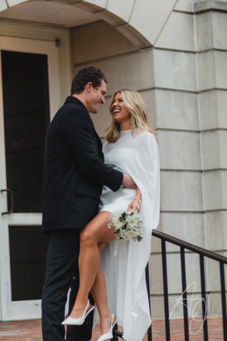 A married couple laughs at a joke on the courthouse steps